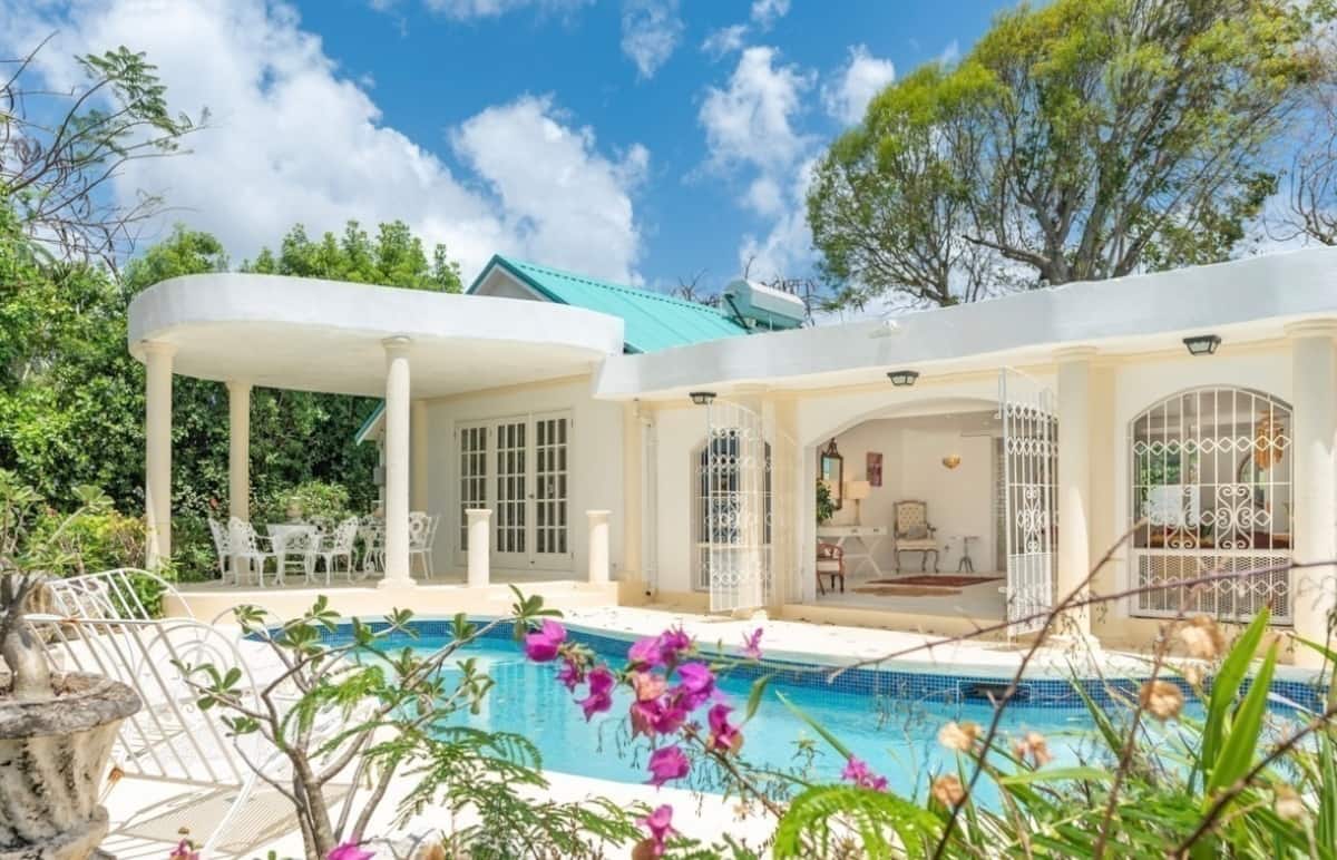 The Polo House pool and curved white veranda surrounded by tropical planting